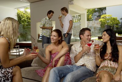 Group of people socializing indoors, holding drinks