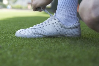 Male tennis player tying his shoe
