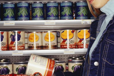 Teenage girl (16-17) looking at canned peaches