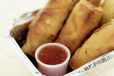 Close-up of spring rolls and sauce in a box