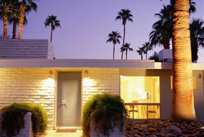 Exterior of brick home with palm trees in background