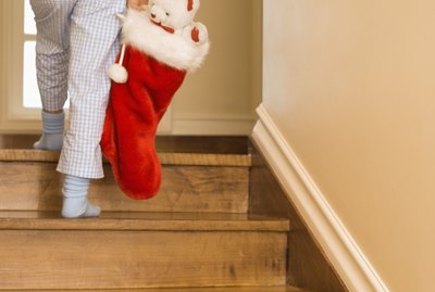 Child walking up stairs with Christmas stocking