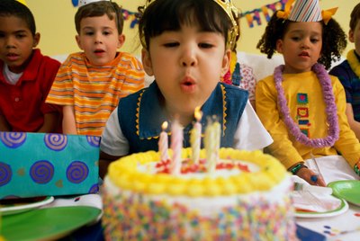Girl (5-7) blowing out birthday candles