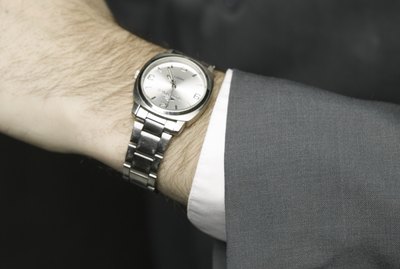 Man checking time, posing in studio, elevated view, close-up, mid section