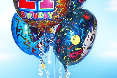 Woman holding twenty first birthday balloons