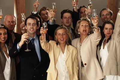 Business people raising glasses, smiling