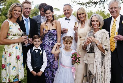 Bride and groom with wedding guests, smiling, portrait