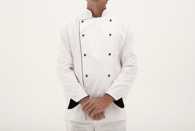 Male chef standing with hands clasped, mid section