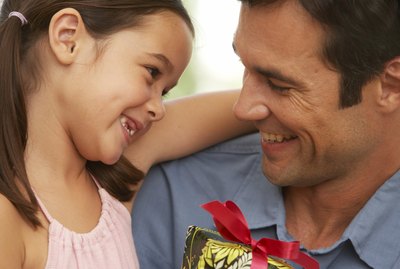 Girl (5-7) embracing father, close-up