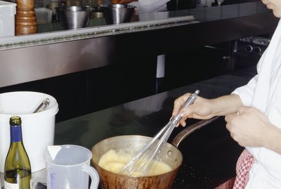Chef stirring ingredients in pan