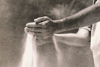 Man running sand through his hands