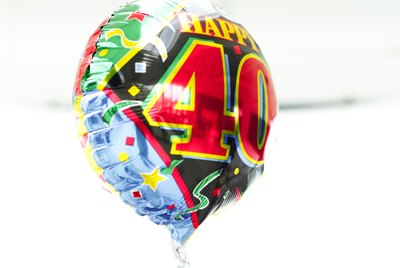 a shiny birthday message helium balloon held up by a thread
