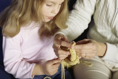 Mother teaching daughter to knit