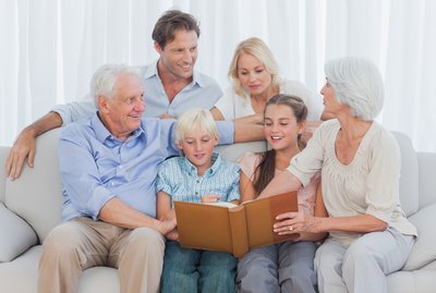 Extended cheerful family looking at a photo album