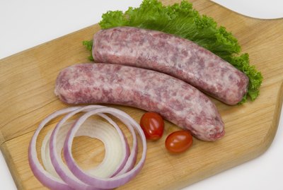 Uncooked bratwurst on a cutting board