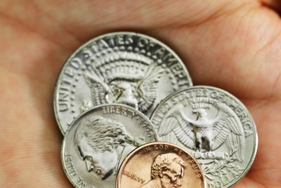 Close-up of a human hand holding various American denominations