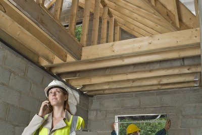 Building inspector with cell phone at construction site
