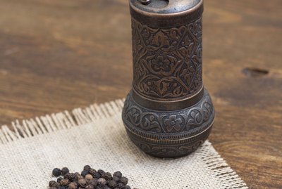 Vintage turkish pepper mill and black peppercorns