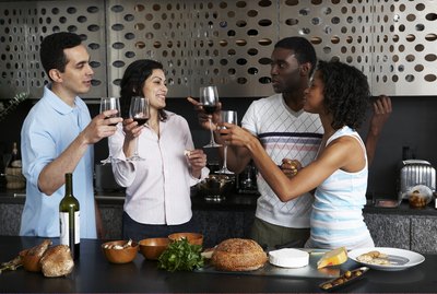 Drinking wine while preparing meal in kitchen