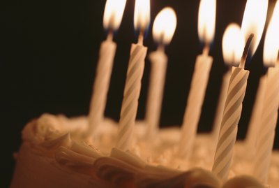 Candles illuminating birthday cake, close-up