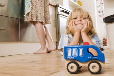 Boy on kitchen floor with toy car