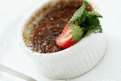 Close-up of a bowl of pudding with a strawberry garnish