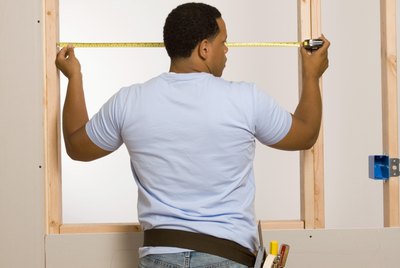 Man measuring window frame
