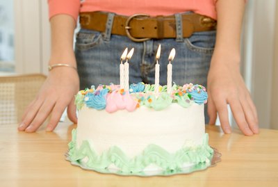 Person standing with birthday cake
