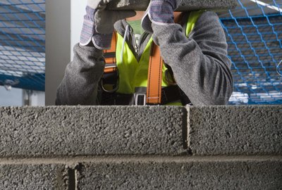Construction worker building cinderblock wall