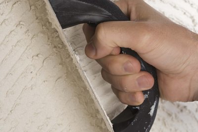 Person putting grout on wall with trowel