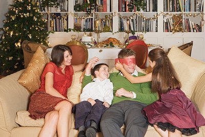 Family playing on sofa at Christmas