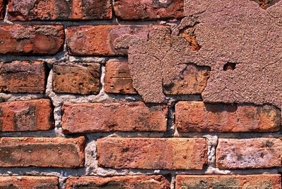 Brick wall with cracked plaster