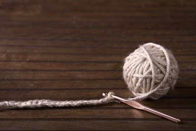 Ball of cream yarn with crochet hook