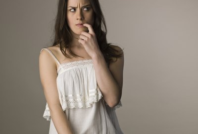 Pensive woman biting finger