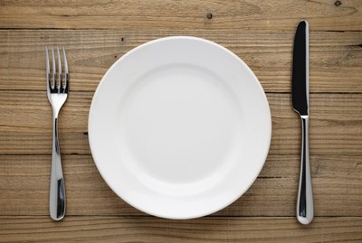 Plate, fork and knife on wood