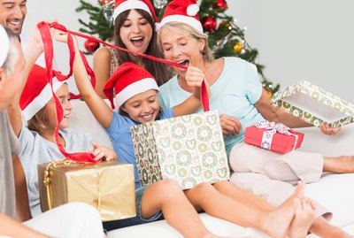 Happy family at christmas opening gifts together