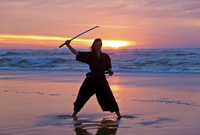 Young samurai women with Japanese sword(Katana) at sunset on the
