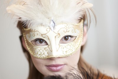Portrait of young woman wearing ornate mask