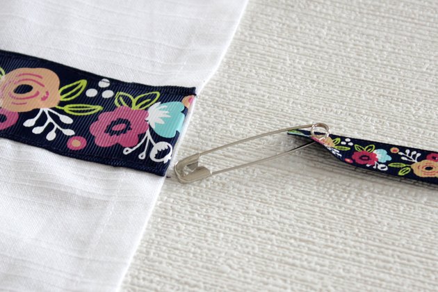 Instead of just hanging your towel over a cupboard door or throwing it on the counter, add a little ribbon to the top so you can give it a place of honor in your kitchen and hang it from your oven door.