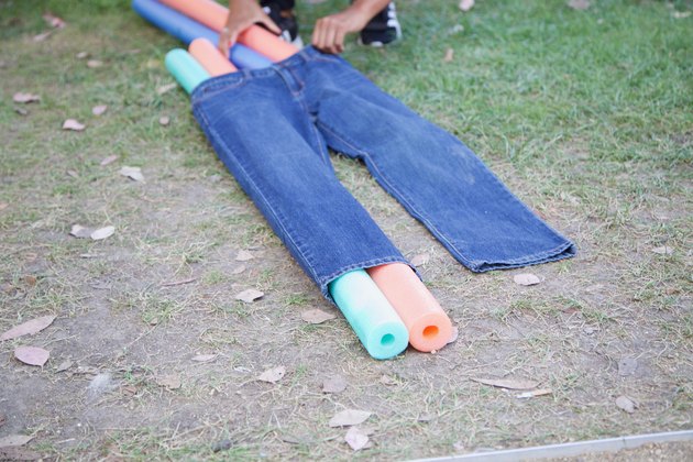 slip pool noodles through jeans legs
