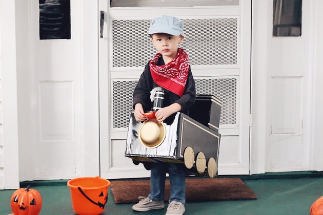Little boy wearing cardboard train costume