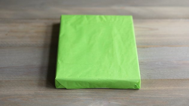 Gift box wrapped in green tissue paper