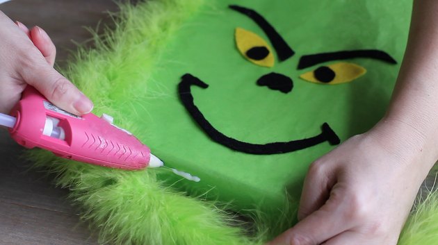 Gluing green feather boa in place