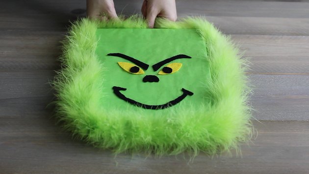 Wrapping green feather boa around perimeter of gift box