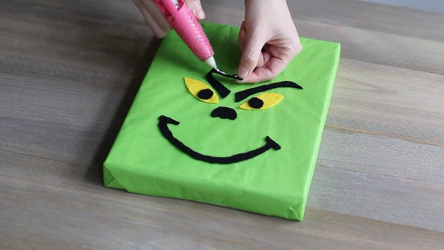 Gluing the Grinch's face features to the box