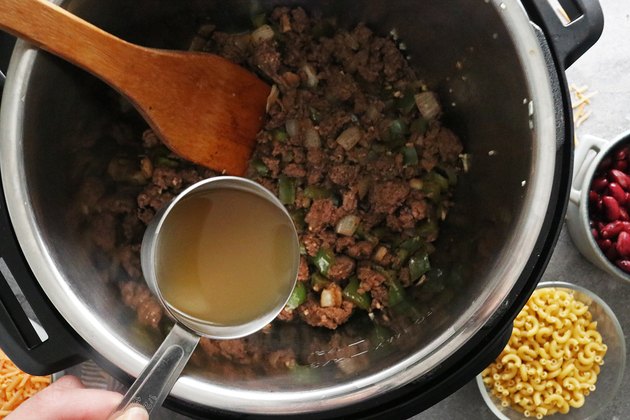 Add broth and scrape the pot