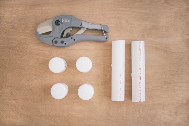 Two PVC pipes, four PVC caps, and a PVC pipe cutter