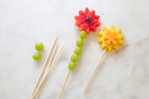 Fruit flowers and green grapes inserted onto wood skewers