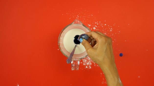 Adding food coloring to starch mixture for DIY Sidewalk Squirt Chalk