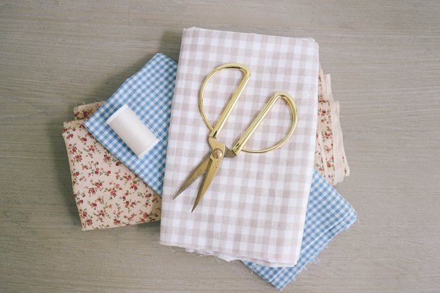 Gingham and floral fabric folded with gold scissors